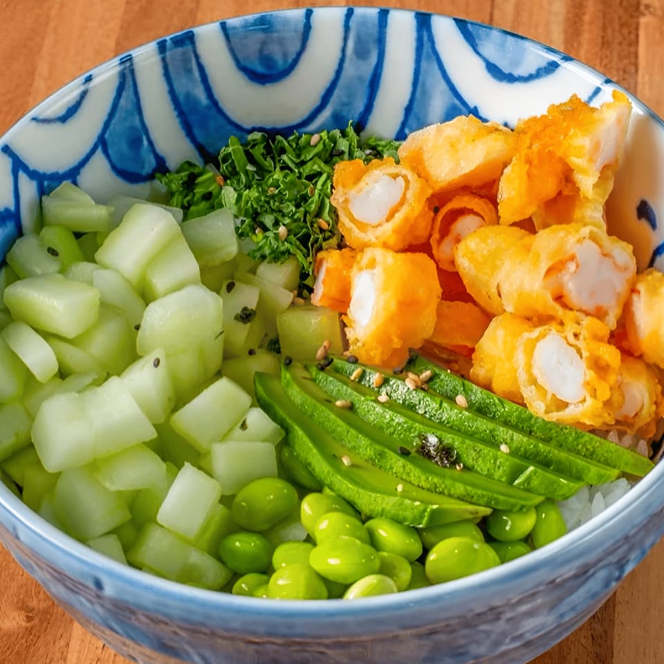 A colorful Japanese poke bowl with crispy shrimp, avocado, cucumber, edamame, and greens.